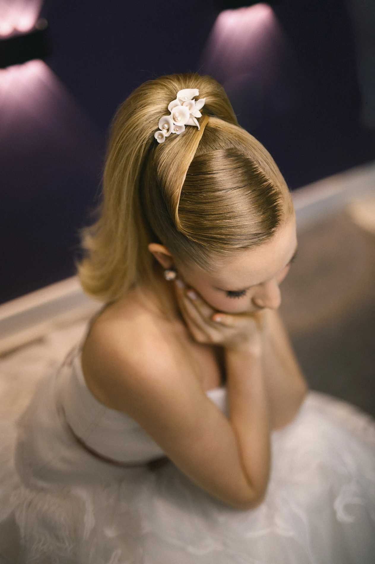 High updo with a floral accessory, viewed from above.