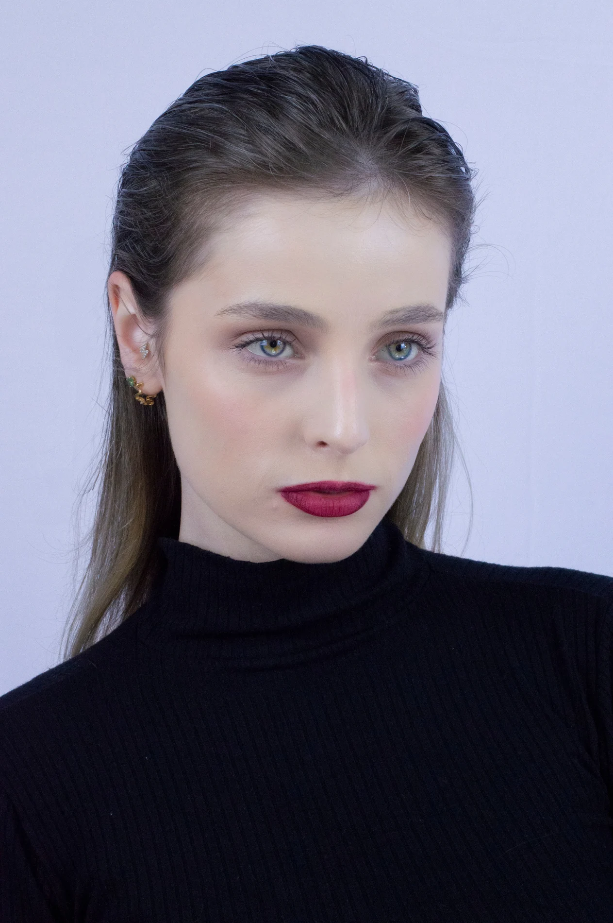 Fashion portrait with dark hair and defined makeup.