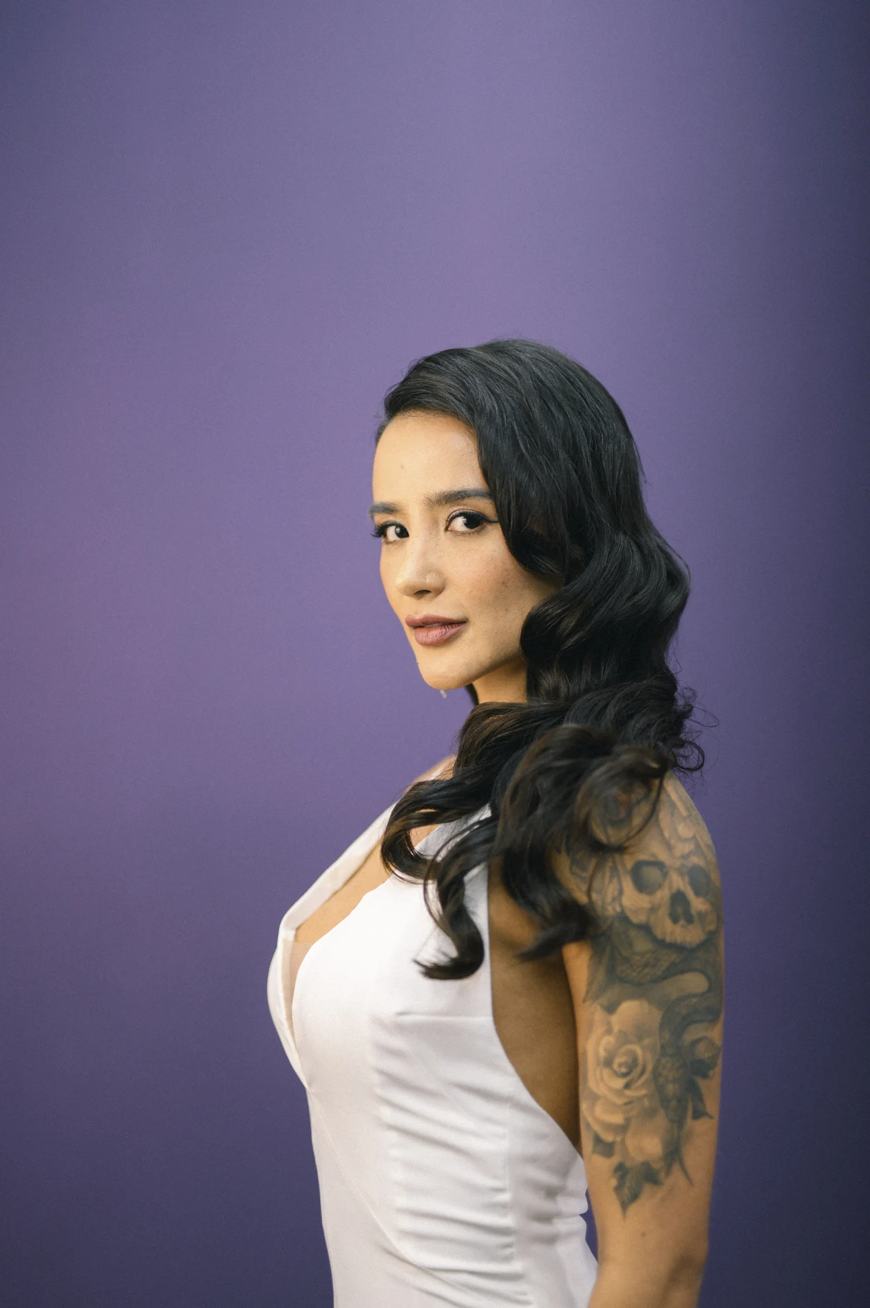 Portrait with dark sculpted waves against a purple background.