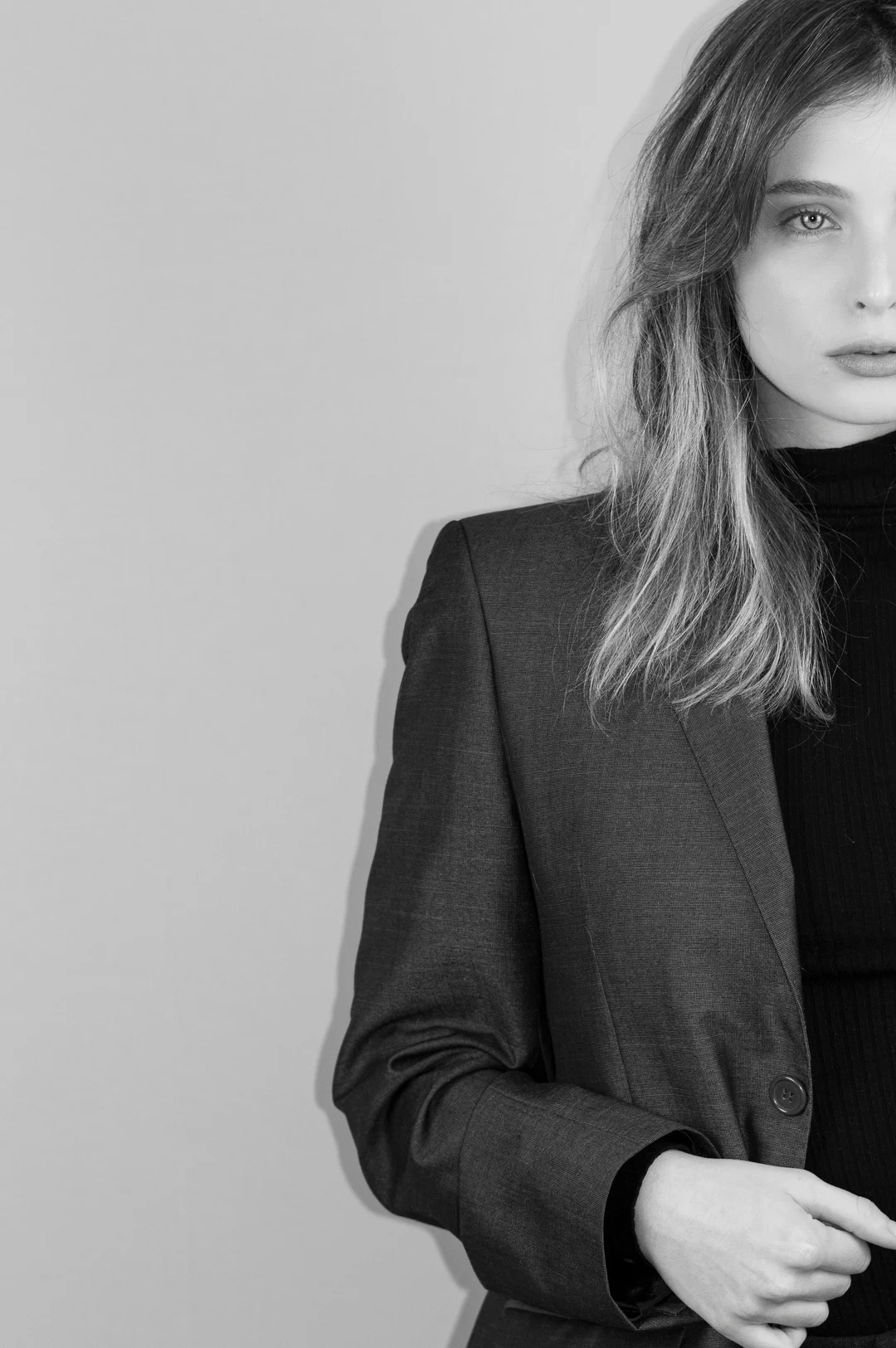 Black-and-white fashion portrait with loose hair and a blazer.