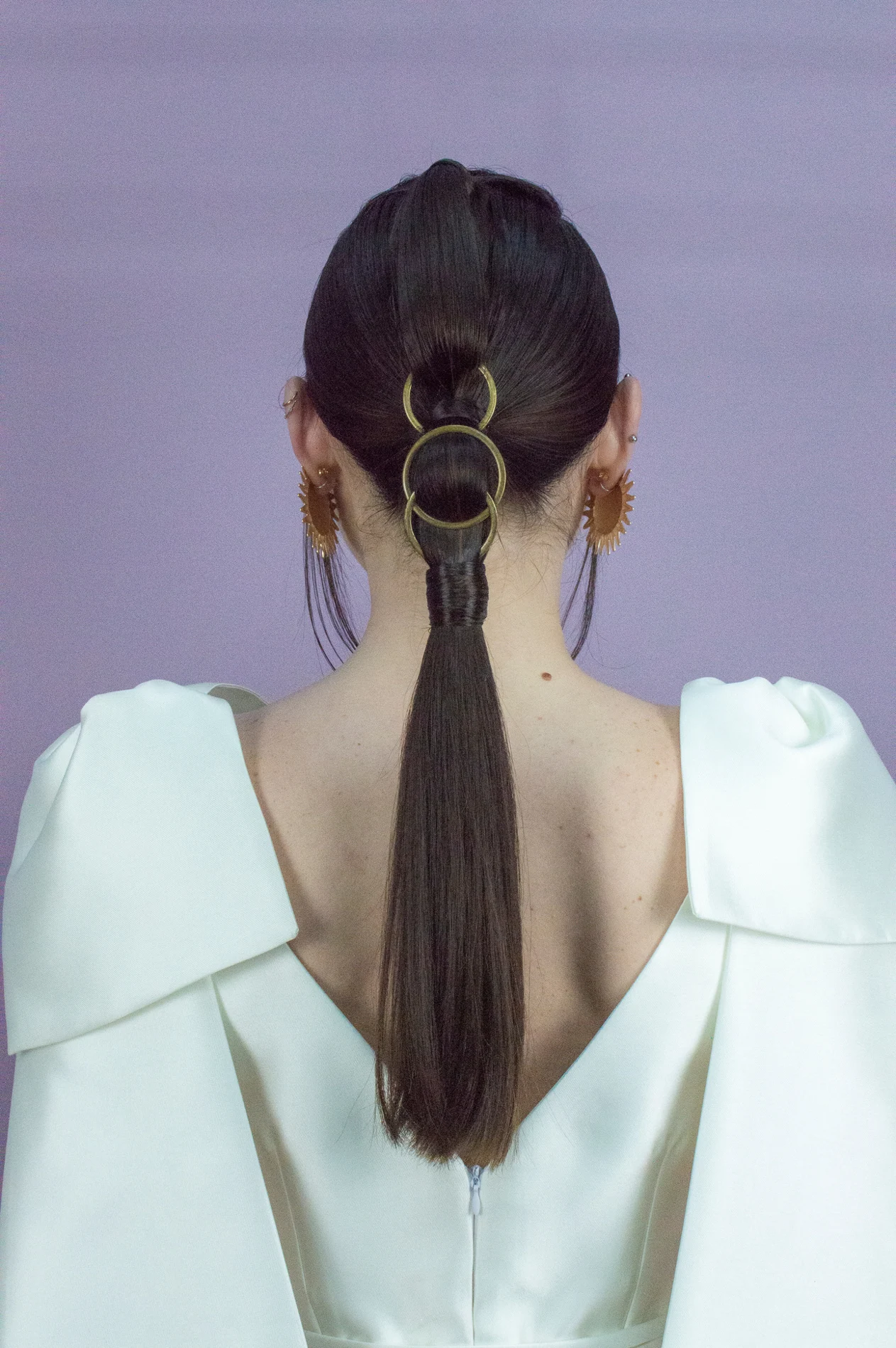 Rear view of a ponytail with circular hair details.