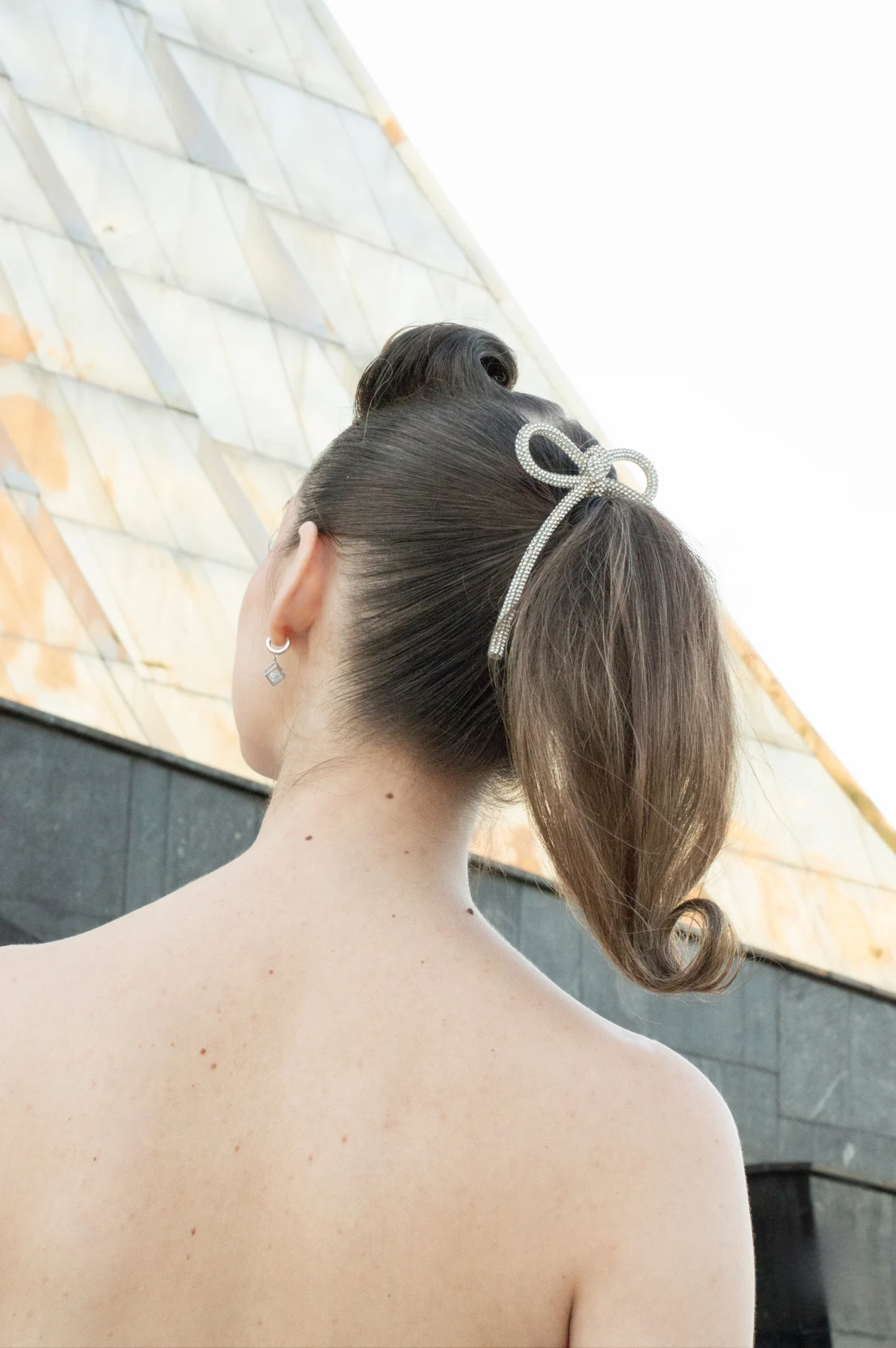 Rear view of an updo with a pale bow.
