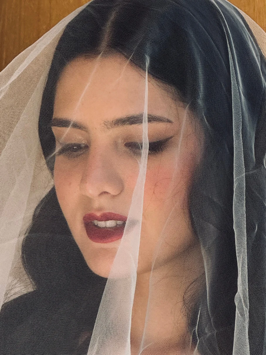 Close bridal portrait with a veil and a rich lip color.
