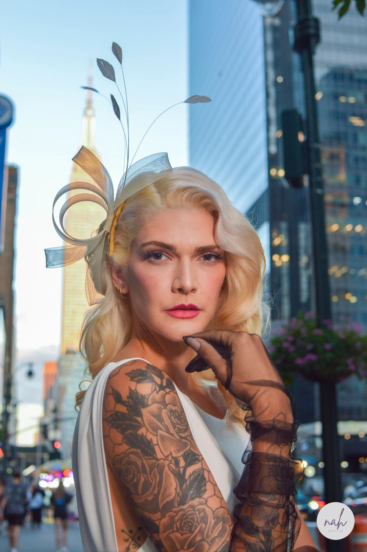 Outdoor bridal portrait with blonde hair, tattoos, and a hair accessory.